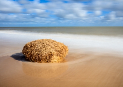 A fallen straw bale on the beach due to coastal erosion at Covehithe on the Suffolk Coast