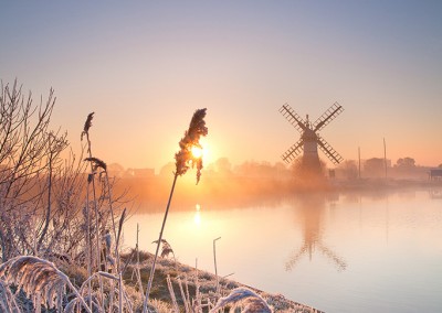 Thurne Drainage Mill at sunrise following an overnight winter hoarfrost on the Norfolk Broads