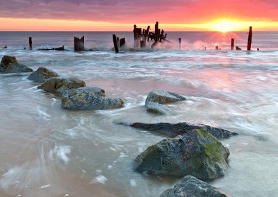 Happisburgh beach and the derelict sea defences captured at sunrise on the Nofolk Coast