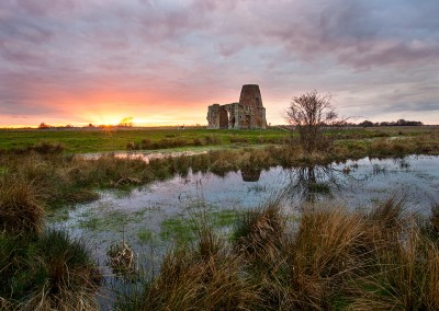 St Benets Abbey at sunset reflecting in medieval fishponds on the Norfolk Broads