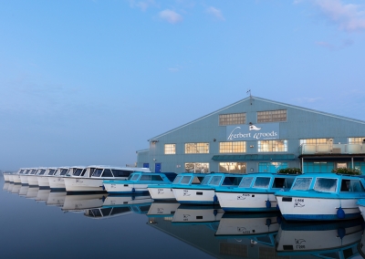 Herbert Woods day boats ready for a busy day on a misty summers morning on the Norfolk Broads