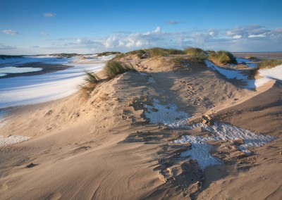 Winter snow on the beach and sand dunes at Holkham Bay on the North Norfolk Coast.