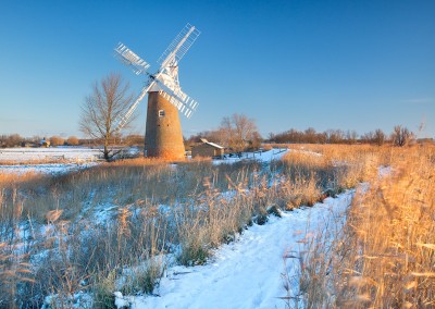 The leaning Hardley Windmill following winter snowfall on the Norfolk Broads