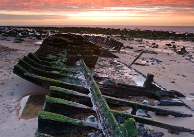 Sunset at old Hunstanton on the North Norfolk Coast. Due to its position on the wash Old Hunstanton is one of the few places on the East Coast where its possible to catch the setting sun over the sea at all times of the year. Here the image shows the shipwreck remains of the Sheraton.