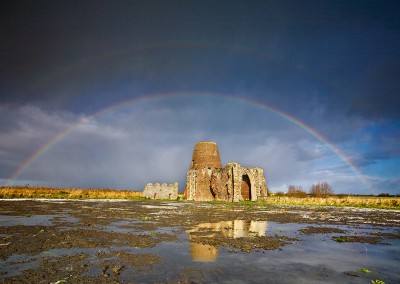 Dramatic hail storm and rainbow captured at the remains of St Benet's Abbey on the Norfolk Broads