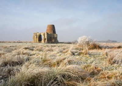 Frozen Marsh land and reeds with St Benet's Abbey in the background on the Norfolk Broads following a winter Hoarfrost