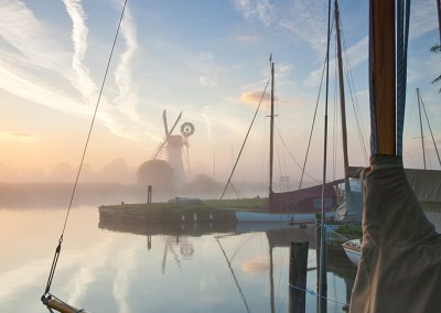 Sailing boat mist calm still peaceful tranquil Norfolk mist River Thurne dawn sunrise boating East Anglia England English Great Britain British UK United Kingdom Thurne windmill drainage mill windpump