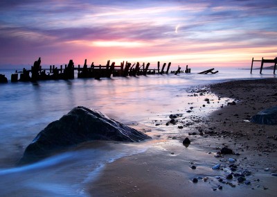 The ruined wooden sea defences and many of the newer rocks which have been placed on Happisburgh beach to help protect against coastal erosion.